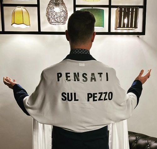 Gabriele Corsi (53) in una divertente parodia di Chiara Ferragni (37) che aveva esordito sul palco dell'Ariston con un abito-manifesto di Dior con la scritta "Pensati libera".