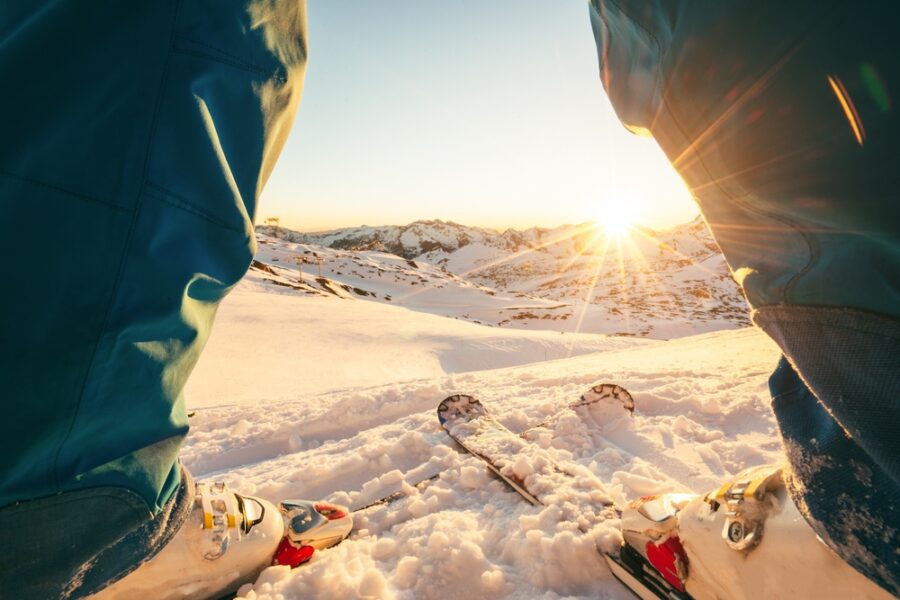 SETTIMABA BIANCA: Le gambe di un uomo con gli sci ai piedi in una bella giornata di sole