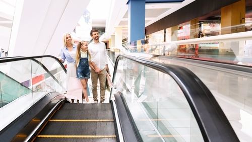 Saldi 2025: il vademecum per viverli al meglio e… sopravvivere! 7 Una famiglia sale con una scala mobile in un centro commerciale.