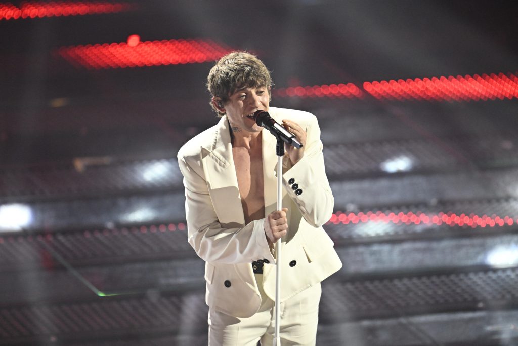 Sanremo 2025: il "pagellone" della prima serata 5 Rkomi, tra i primi a esibirsi. Dimentica la "maglietta della salute" sotto la giacca bianca su panta bianco e Gerry Scotti lo fa notare.