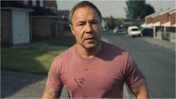 Stephen Graham (51 anni) in una scena di Adolescence. Grahm, oltre ad interpretare Eddie (il padre del protagonista), è anche co-sceneggiatore della serie insieme a Jack Thorne.