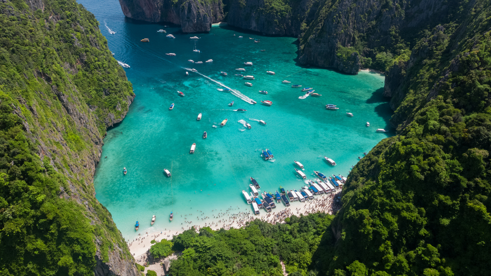 Maya Bay, in Thailandia, luogo iconico delle riprese del film "The Beach" con Leonardo DiCaprio. Un luogo solitario e paradisiaco nella pellicola del 2000, affollato di turisti venticinque anni dopo, tanto da costringere le autorità a chiudere la spiaggia per alcuni periodi per favorire il risanamento ambientale. - © Shutterstock